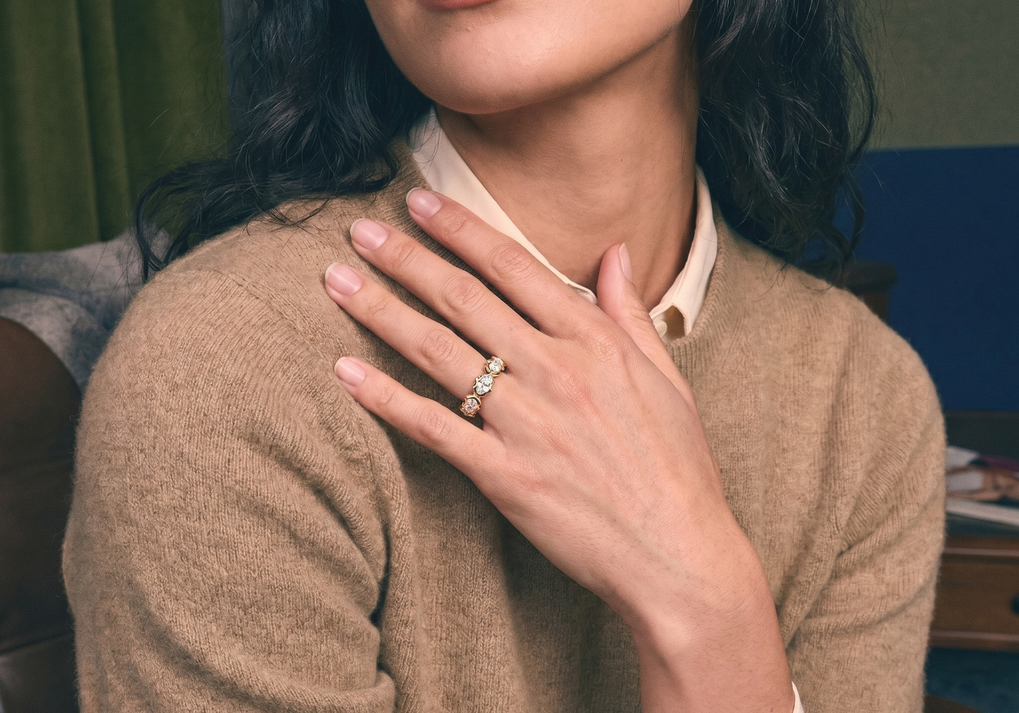 Hand wearing a custom lab grown diamond gold eternity wedding band, bridal styling on ivory silk