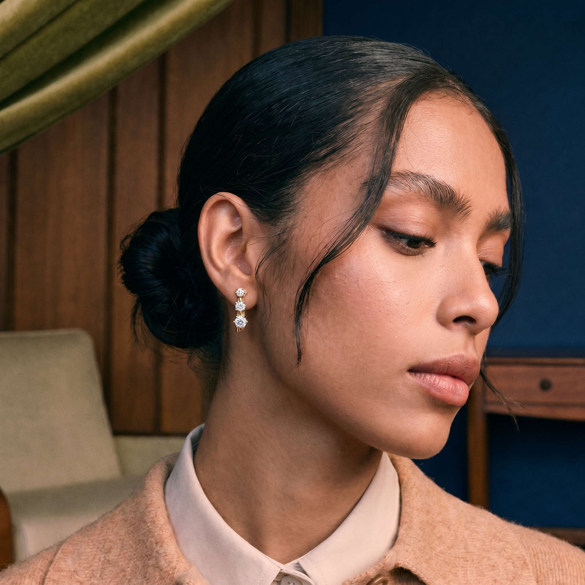 Model wearing a round brilliant lab grown diamond stud earring in solid gold, soft natural light
