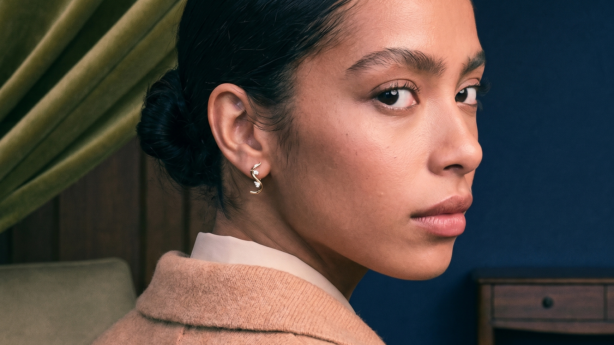 Model wearing solid gold lab-grown diamond hoop earrings in soft natural window light
