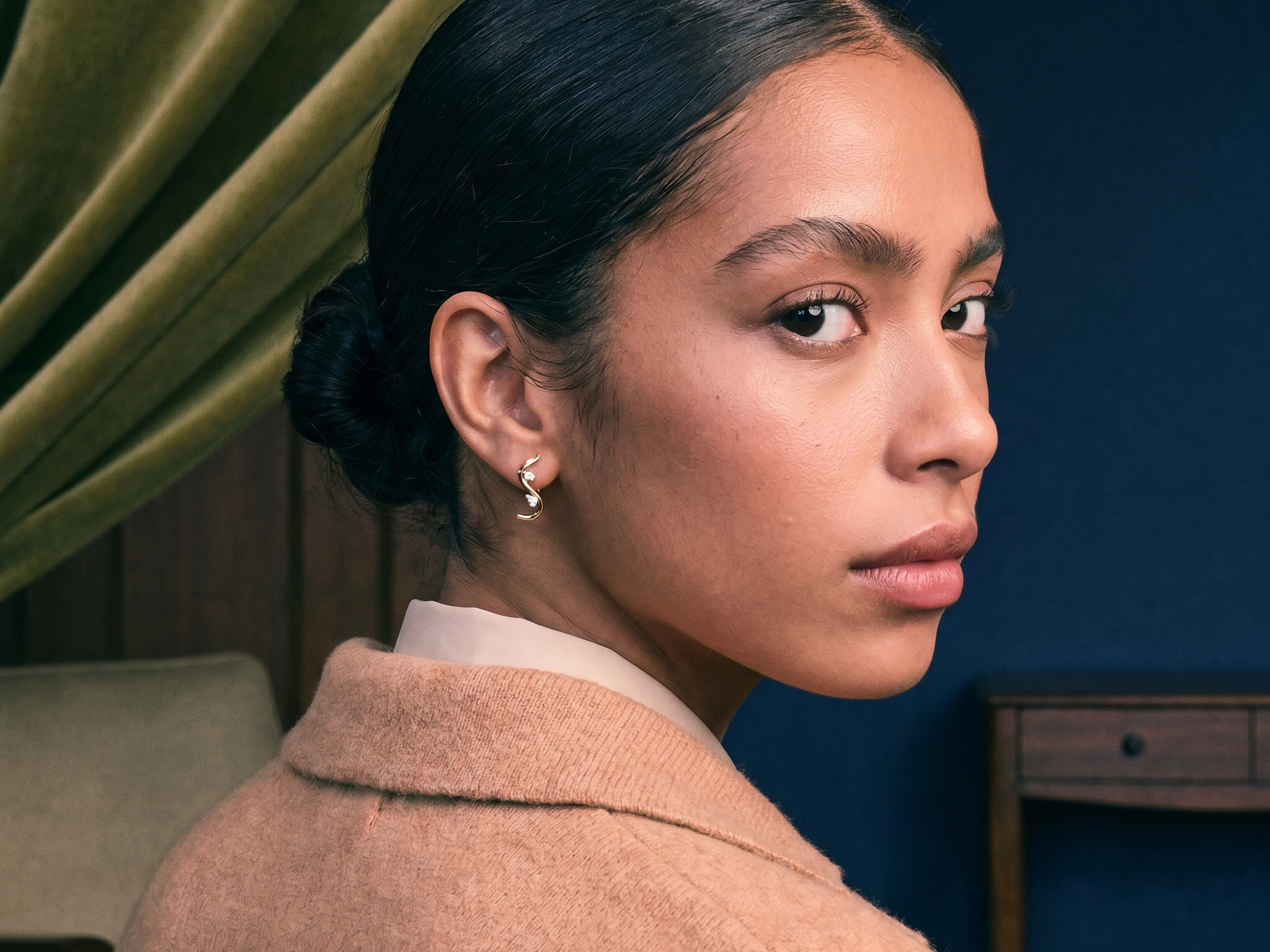 Model wearing solid gold lab-grown diamond hoop earrings in soft natural window light