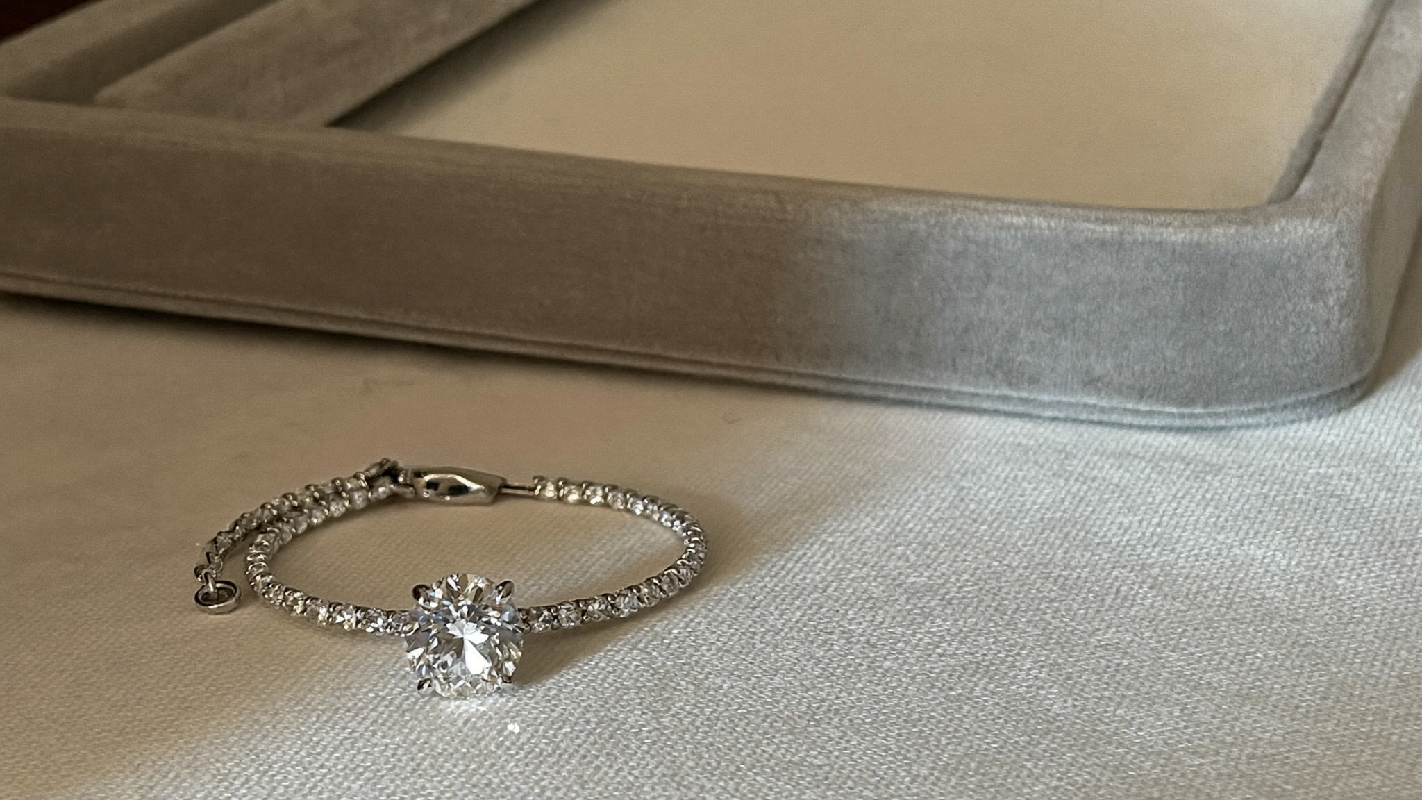 IGI certified lab grown diamond bracelet on a grey velvet jewelry tray in natural light